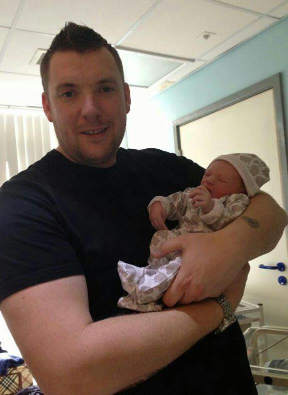 Dad holding his new baby proudly